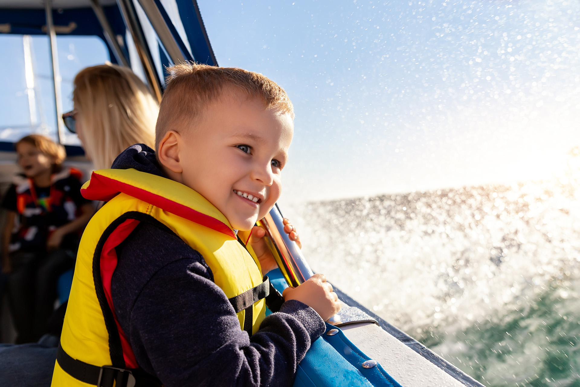 Boy wearing a lifejacket on a boat on Lake Simcoe