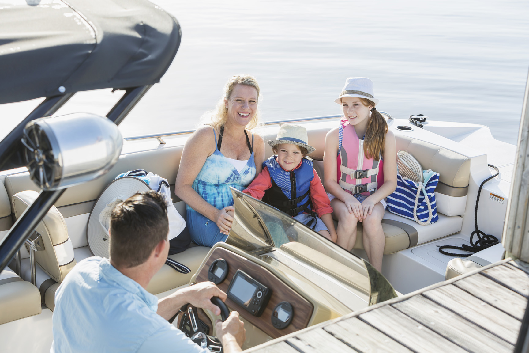 Family of four sitting on a boat at a dock slip on Lake Simcoe