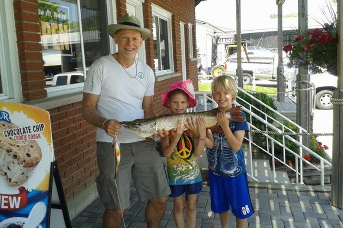 Grandfather and Grandchildren holding a fish caught on Lake Simcoe