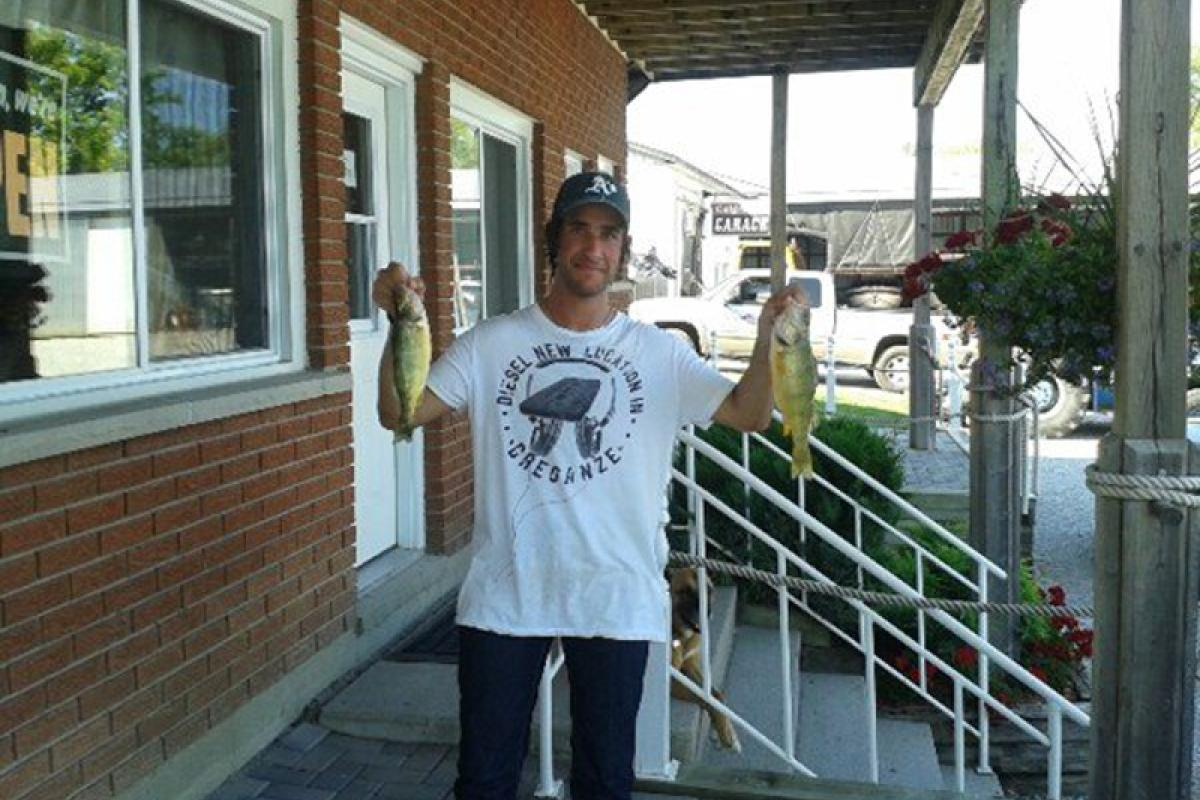 man holding a fish caught on Lake Simcoe